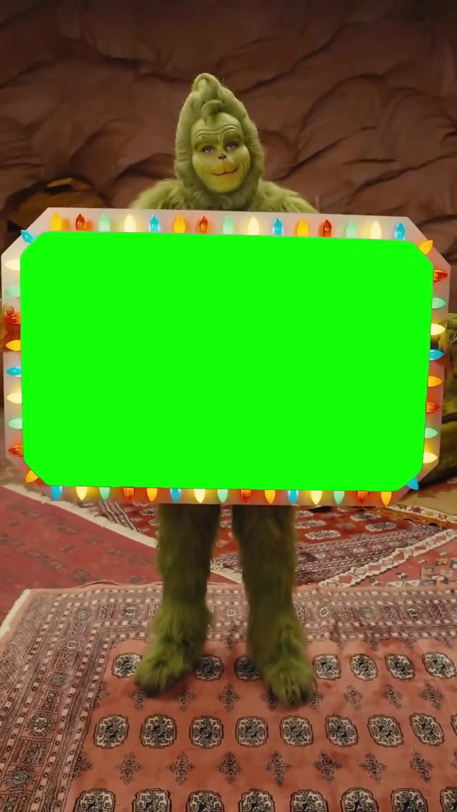 Grinch holding a sign green screen